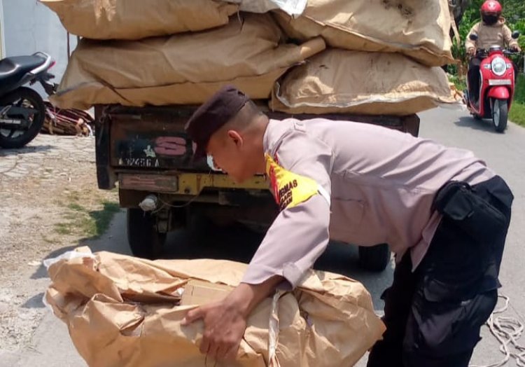 Bhabinkamtibmas Polsek Pebayuran Membantu Membereskan Barang Muatan Pengendara Mobil Pick Up Yang Terjatuh